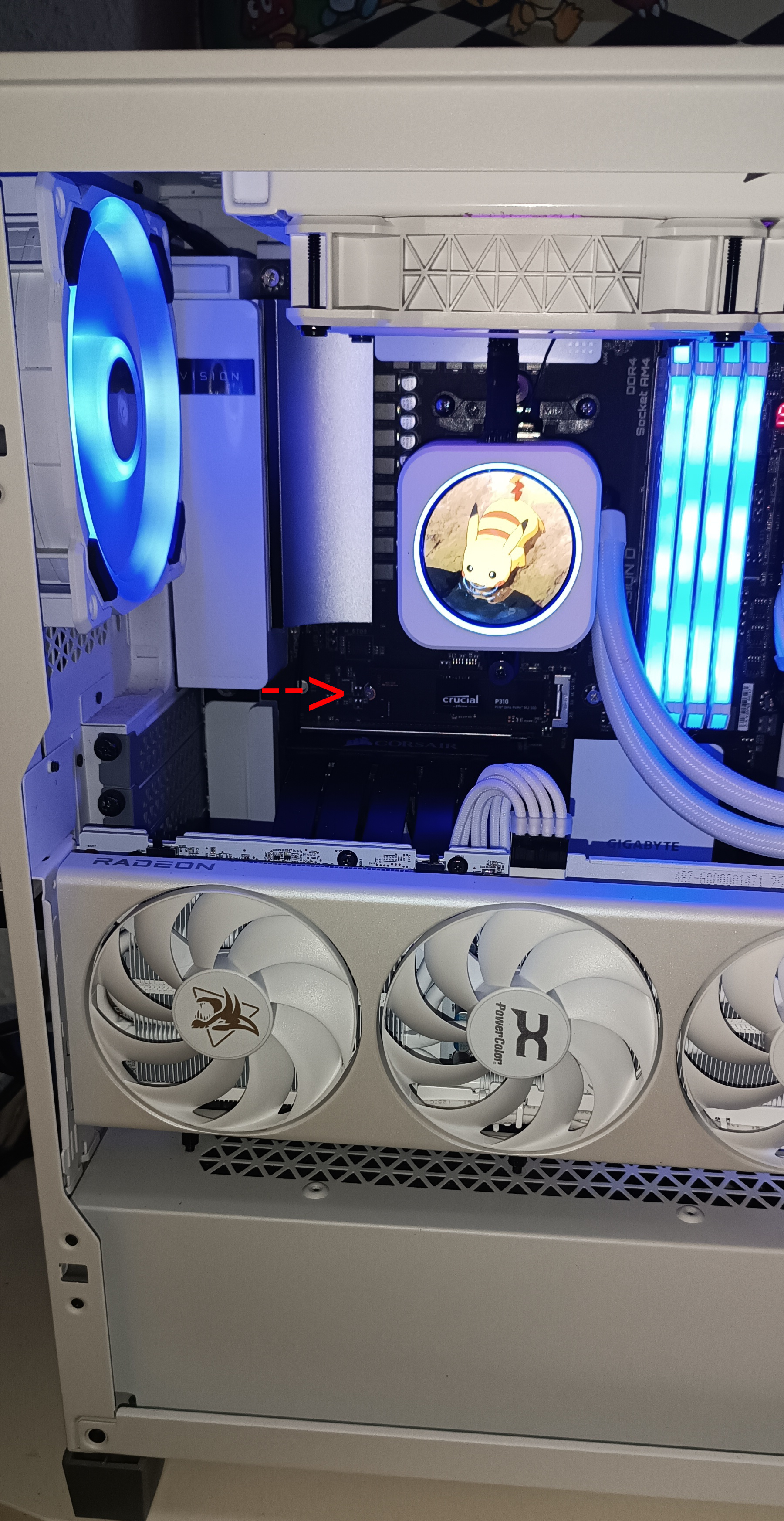 Installed M.2 SSD with an arrow pointing to its tiny mounting screw above the power supply compartment